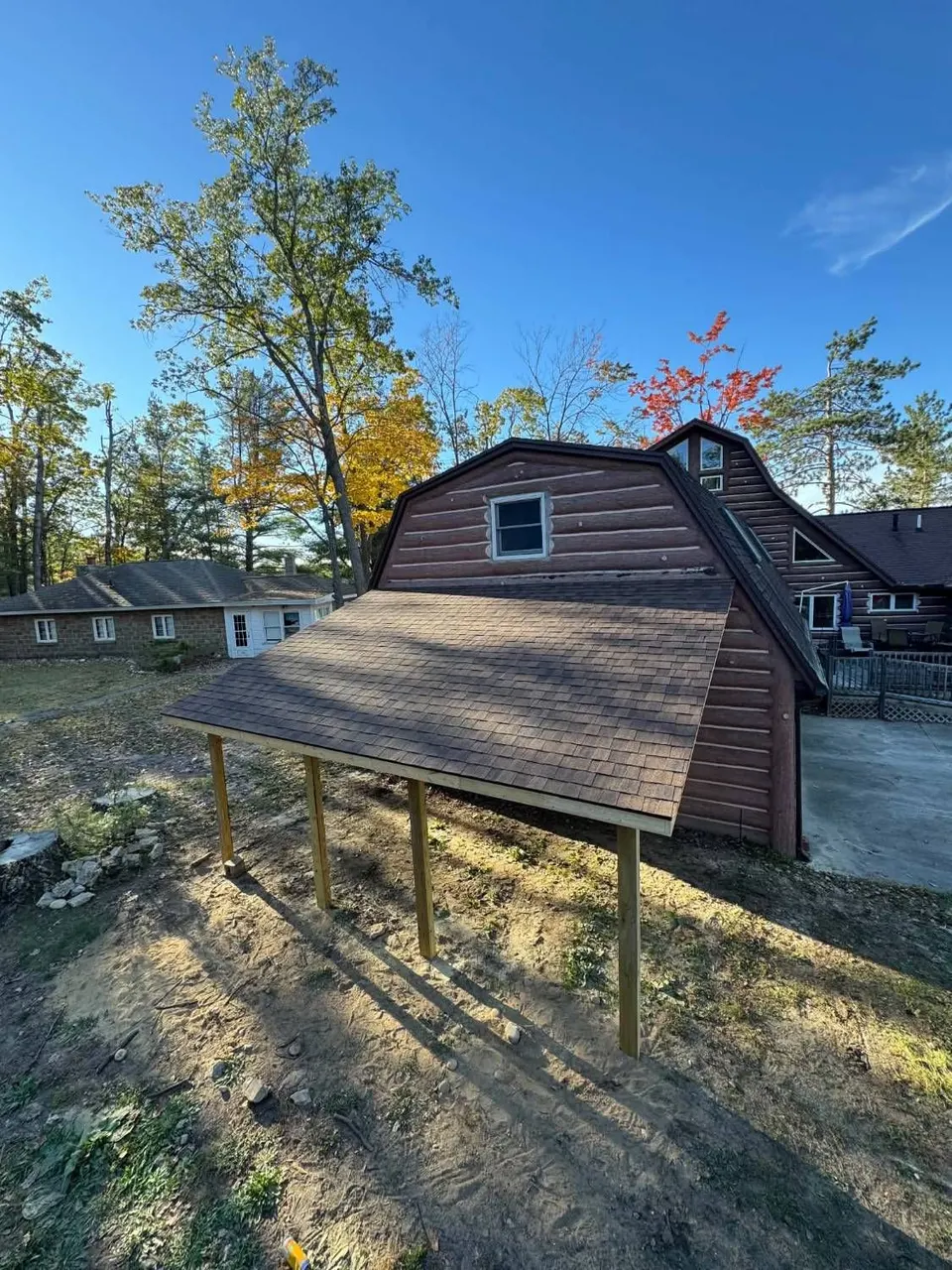 Finished shingled lean-to roof on the side of a gambrel barn