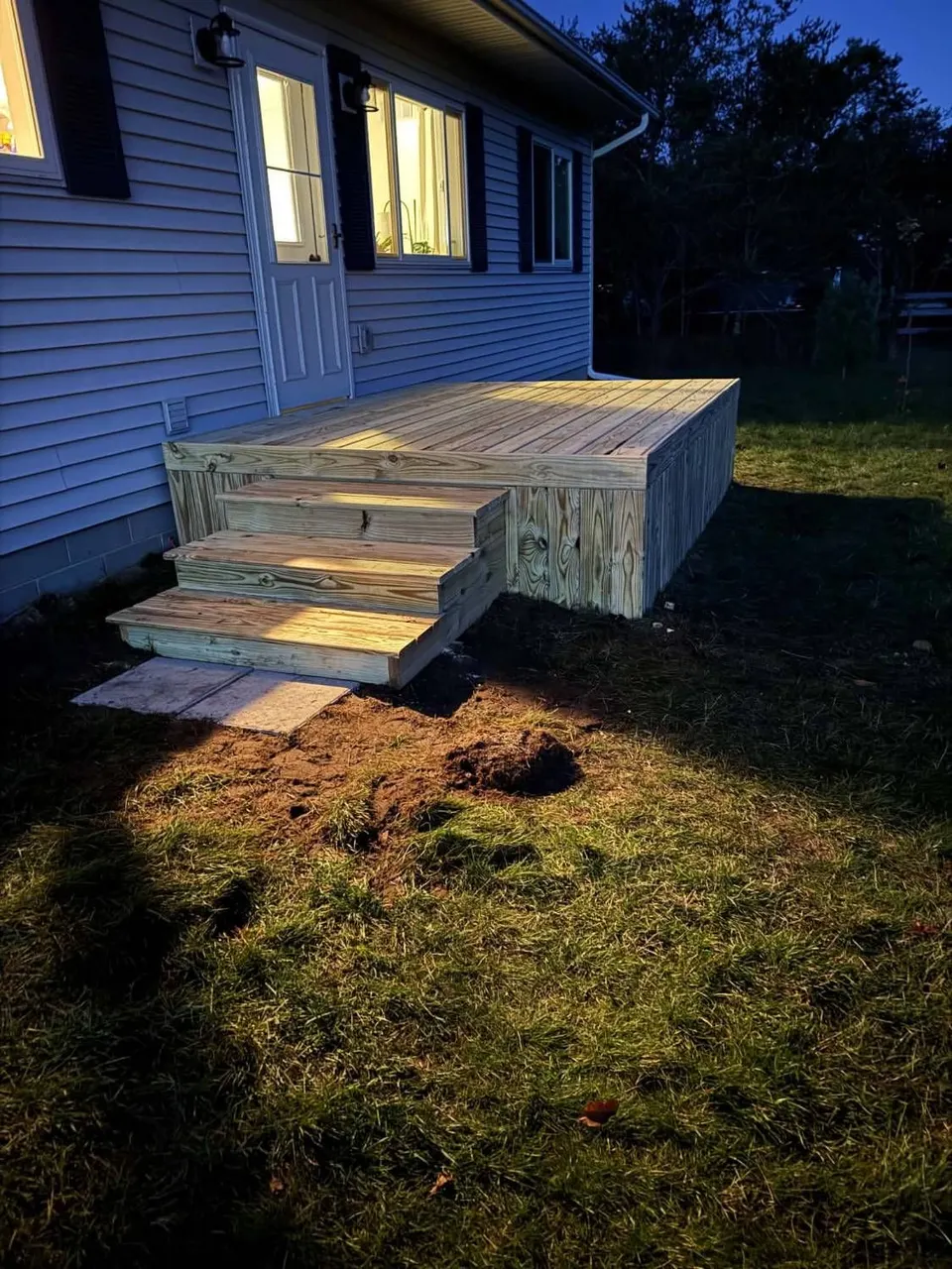 Pressure-treated deck with wide side stairs at a back door