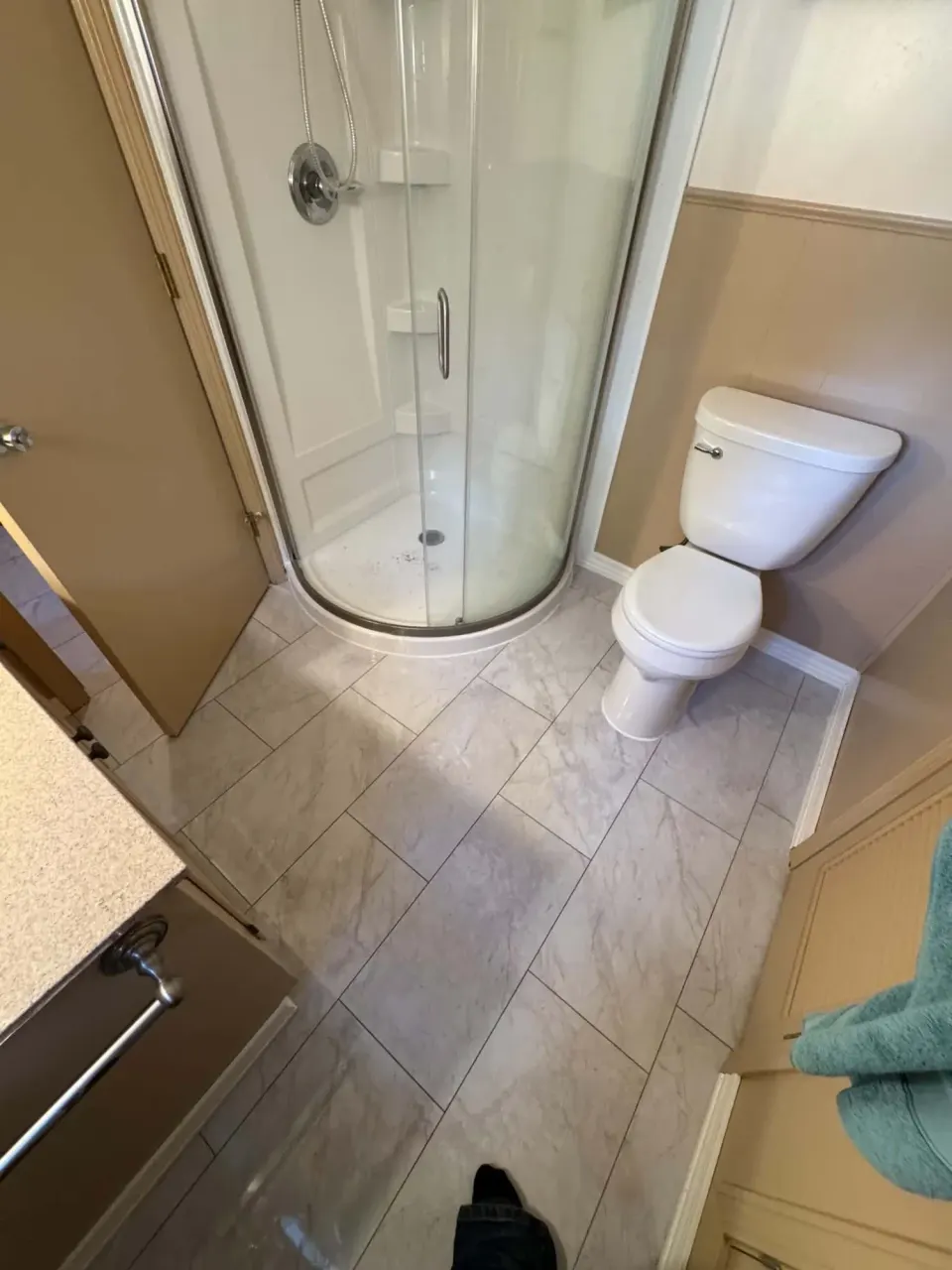 Bathroom with a corner shower and new large-format vinyl tile flooring