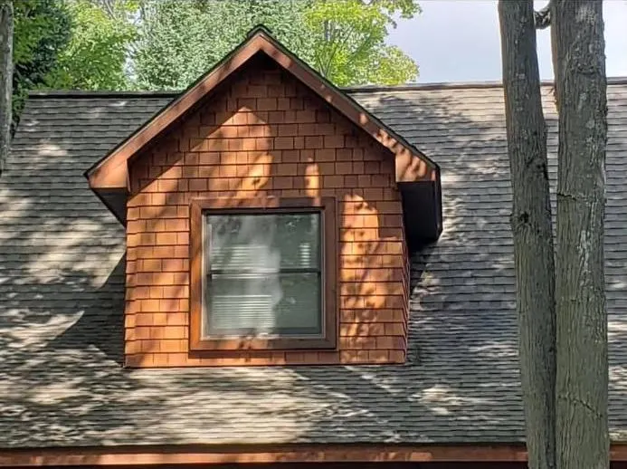 Roof dormer finished with natural cedar shake siding and wood trim