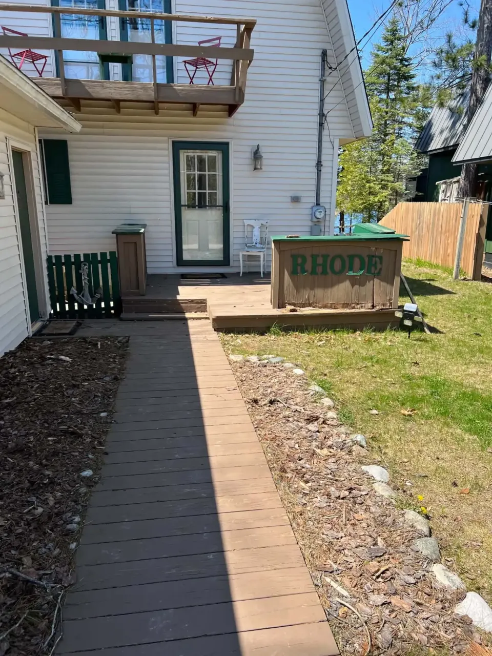 Before: an old wood walkway and weathered entry deck on a two-story home